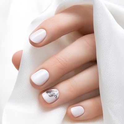 Female hand with white dandelion nail design